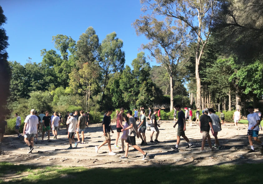 Group of people meandering through a garden labyrinth