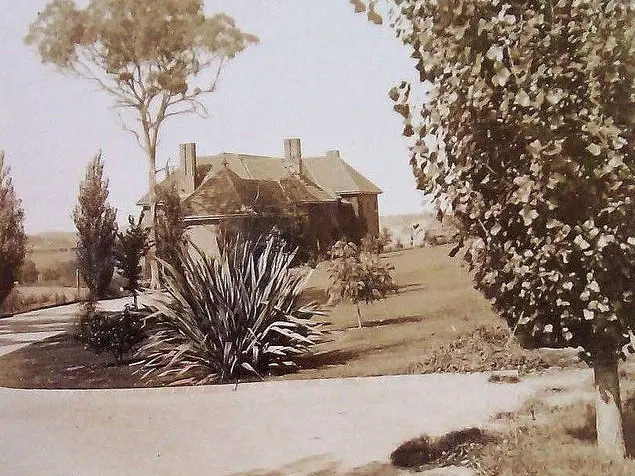 Black and white photo of gardens and building.